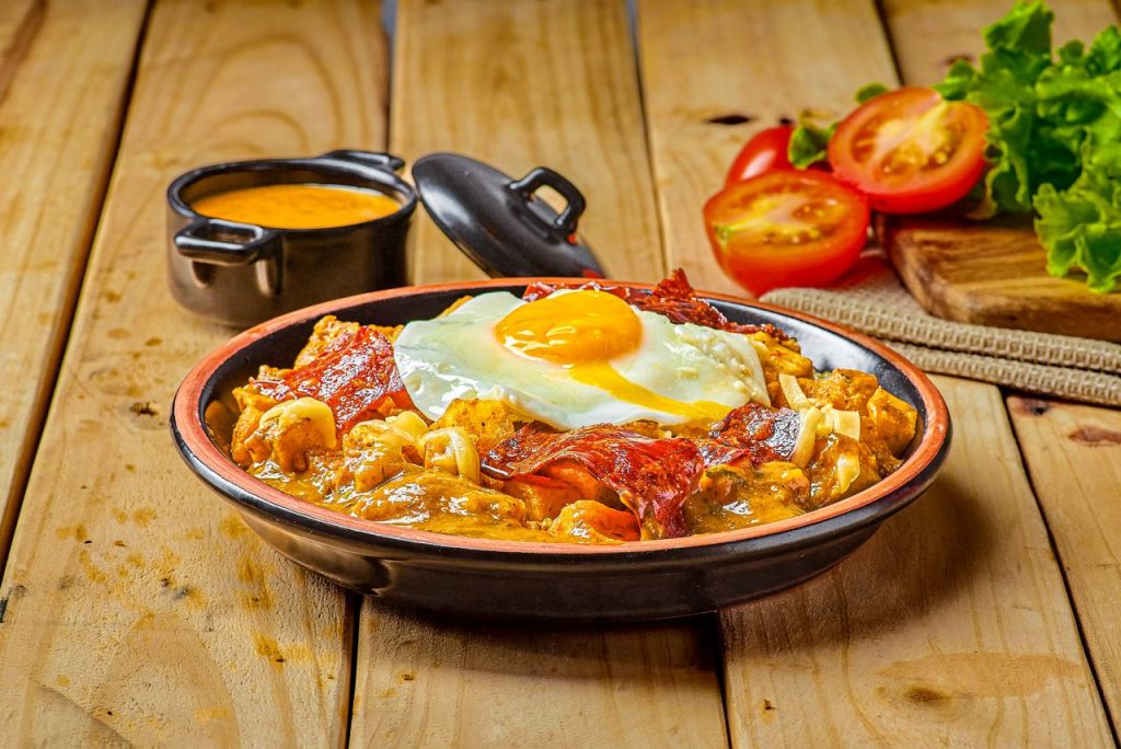 Deliciously plated traditional Mote Pillo with a fried egg, served in a rustic Quito restaurant.